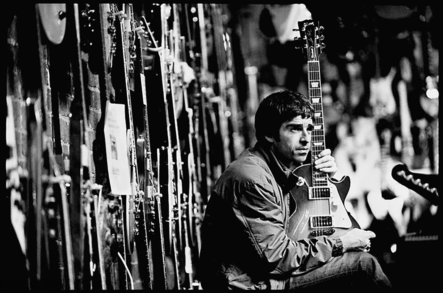 Oasis, Noel Gallagher at Music Ground guitar shop, Leeds, 2001 by Jill Furmanovsky