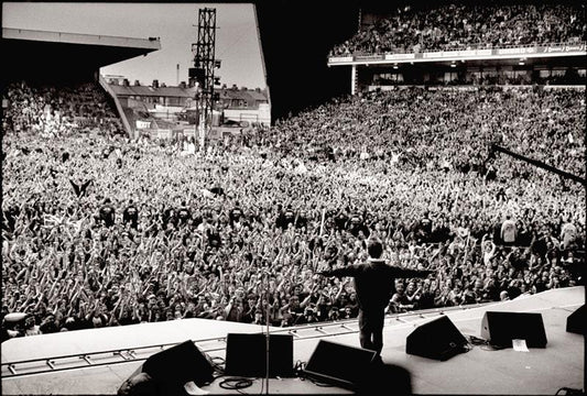 Oasis, Noel Gallagher arms outstretched, Manchester, April 1996 by Jill Furmanovsky